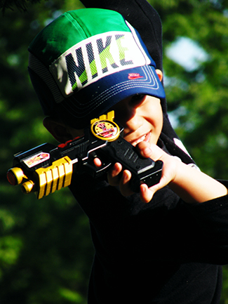 A photograph shows a child pointing a toy gun.