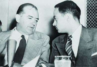 A photograph shows Joseph McCarthy and Roy Cohn engaged in a quiet conversation.