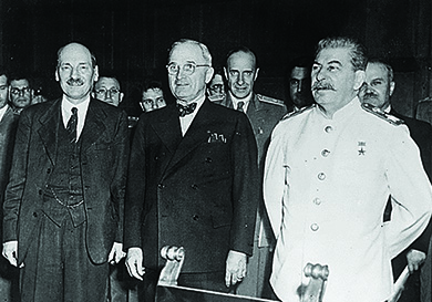 A photograph shows Clement Atlee, Harry Truman, and Joseph Stalin standing in front of a group of officials.