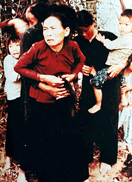 A photograph shows a group of Vietnamese women and children holding one another tightly, with looks of terror on their faces.