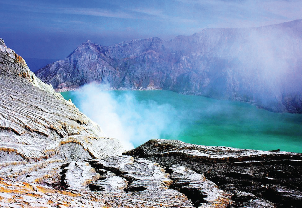 A lake is shown surrounded by rocky, mountainous peaks. A white vapor rises from the ground near the lake.