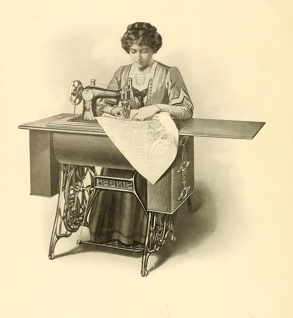 A woman sewing using an old foot-pedal sewing machine