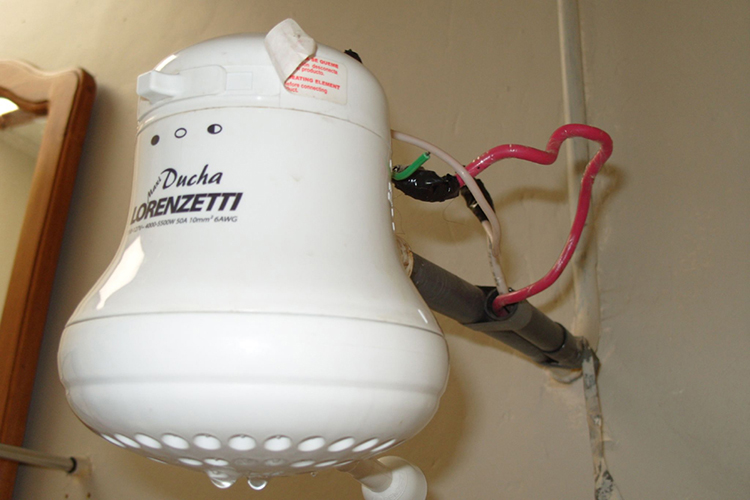 Photograph of an electric hot water heater connected to the electric and water supply