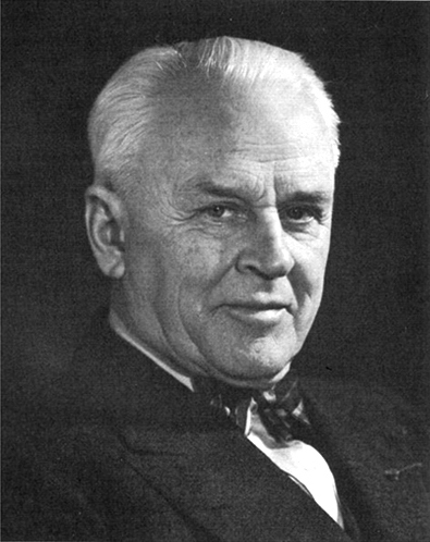 Black and white image of physicist Robert Millikan wearing a jacket and a bow tie.