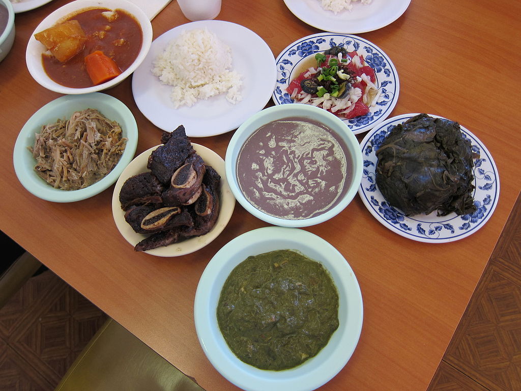 Picture of different bowls and plates containing Hawaiian foods described in the caption.