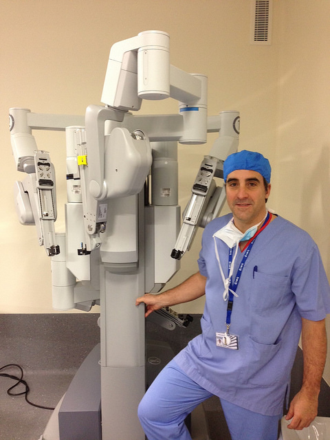 A surgeon standing next to the da Vinci robot