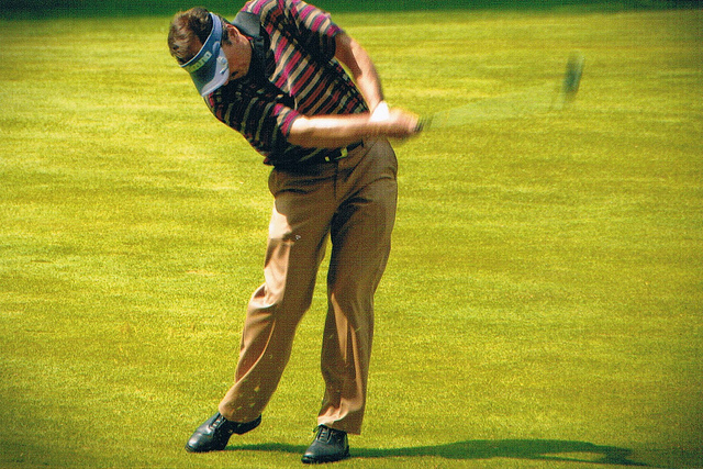 a man mid-swing playing golf