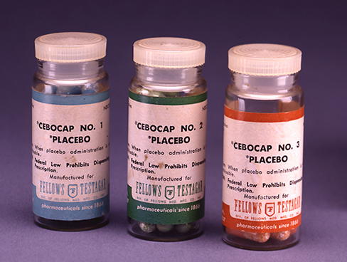 A photograph shows three glass bottles of pills labeled as placebos.