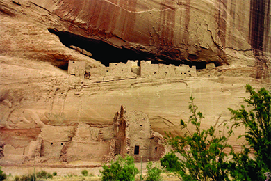 A photograph of Anasazi cliff dwellings shows blocky adobe structures with window and door openings, some of which are set atop a high, sheer cliff.