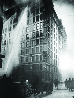 A photograph shows firefighters directing a massive spray of water at the blaze in the Triangle Shirtwaist Factory.