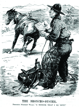 A cartoon entitled “The Broncho-Buster” depicts Woodrow Wilson dressed as a cowboy, holding a book that is open to a page headed “Theory of Equitation.” A saddle is at his feet. A saddleless horse wanders nearby with “Mexico” printed on its rear end. The caption reads “President Woodrow Wilson. ‘I wonder what I do next.’”