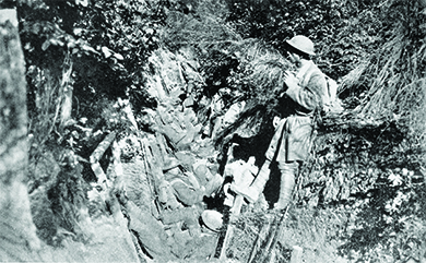 A photograph shows several U.S. soldiers sitting and standing in a trench.