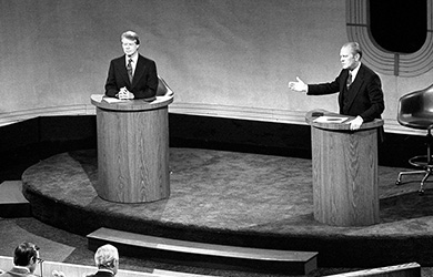 A photograph shows Gerald Ford and Jimmy Carter engaged in debate from two lecterns. Ford is speaking and gesturing toward Carter with one hand.
